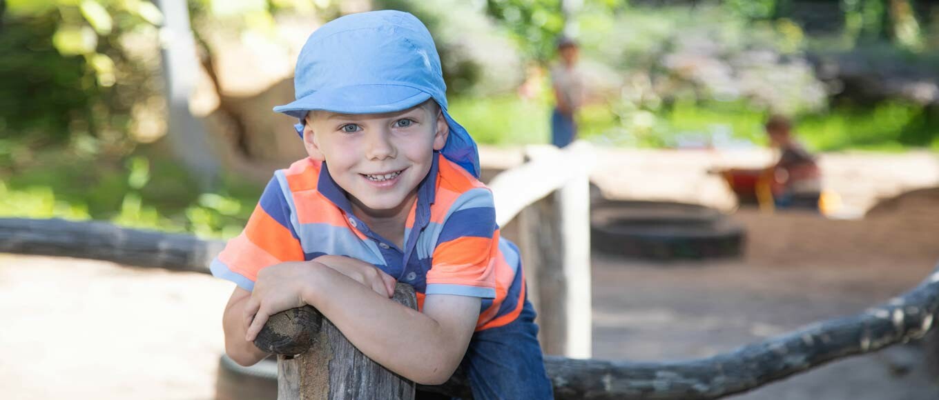 Ein Junge auf dem Spielplatz schaut in die Kamera